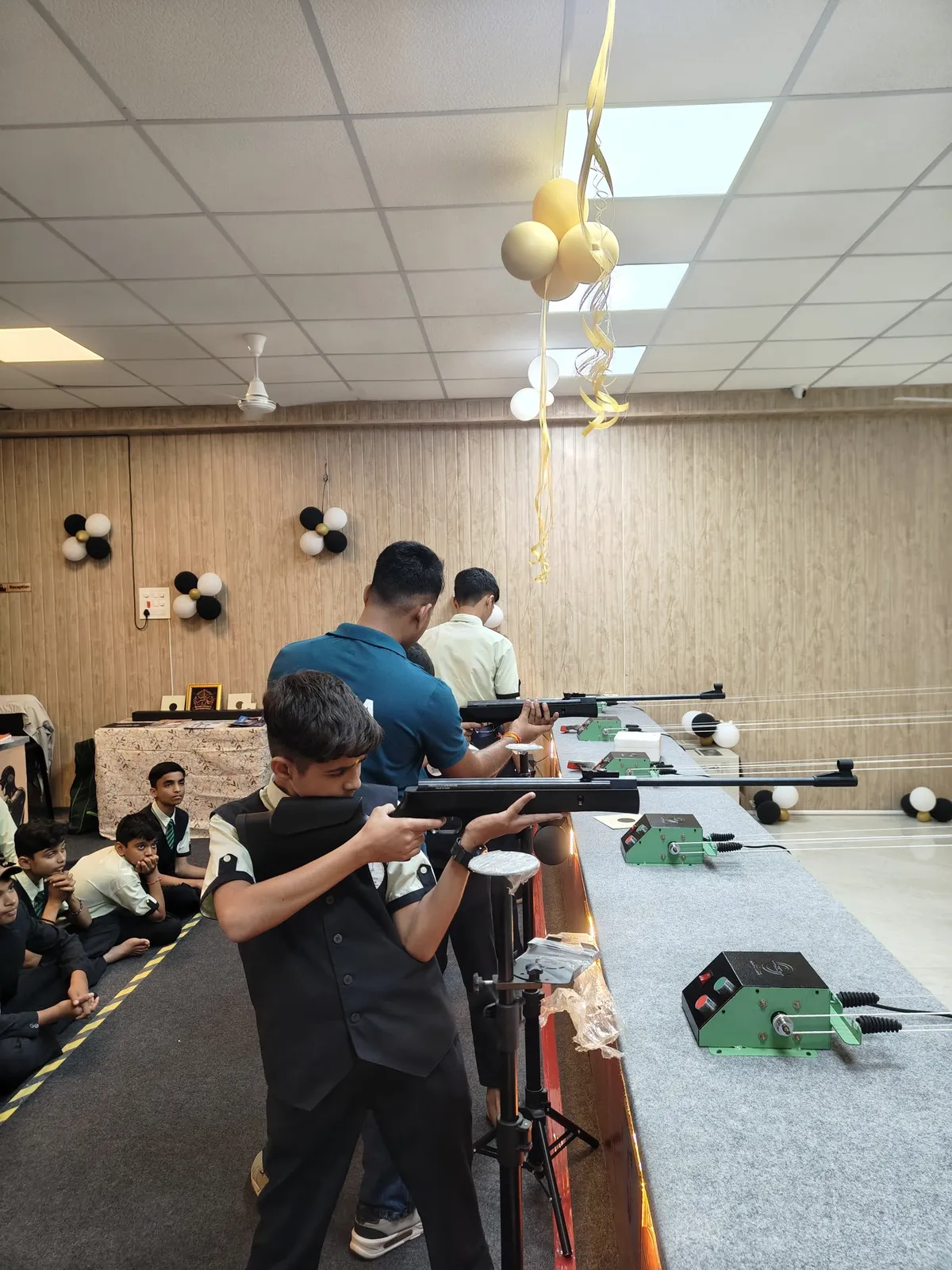 A student aiming an air rifle at the firing line