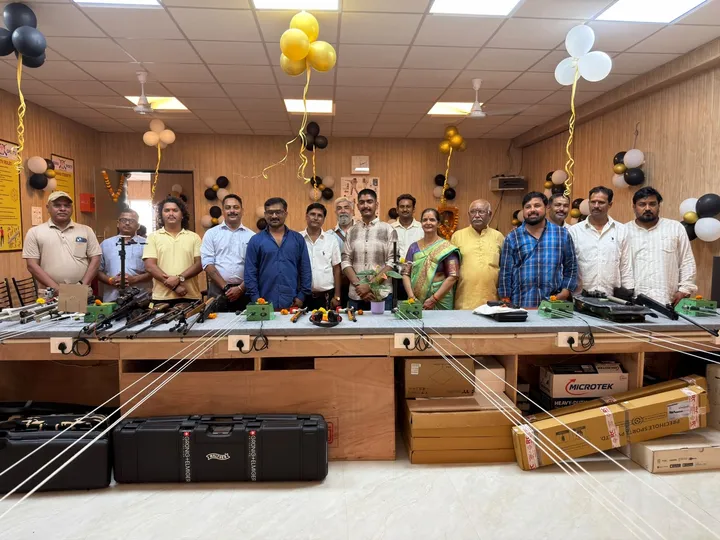 Guests and well-wishers standing in front of the shooting equipment table in the academy hall
